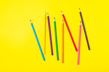 Colored pencils on a bright colored background. Equipment for coloring. Stationery for...