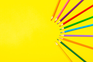 Colored pencils on a bright colored background. Equipment for coloring. Stationery for...