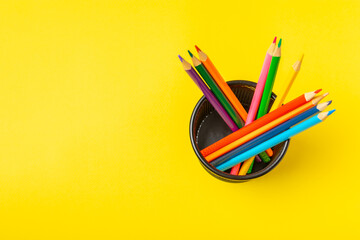 Colored pencils on a bright colored background. Equipment for coloring. Stationery for...