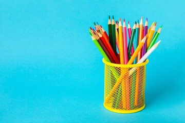 Colored pencils on a bright colored background. Equipment for coloring. Stationery for...