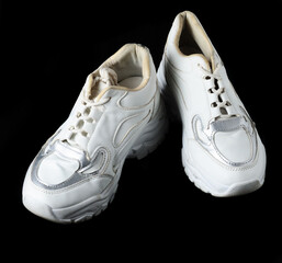 Preowned white running shoes with visible wear vintage sports sneakers black background
