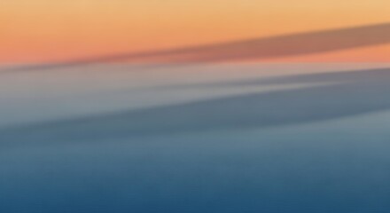 Abstract blurred background with gradient of orange, blue, and grey, creating a soft, dreamy, and calming effect.