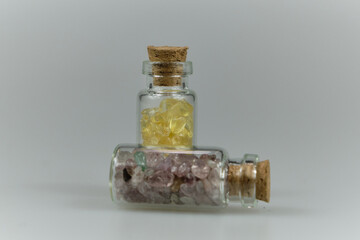 Pequeños recipientes con gemas y minerales amarillo y violeta