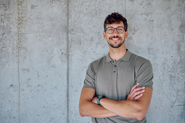 Portrait of a confident businessman smiling with arms crossed, showcasing leadership and success in a corporate setting