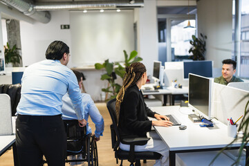 Coworkers and manager working together in a modern inclusive office, promoting diversity and...