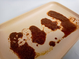 Dirty plate isolated, empty bowl after dinner, ready lunch, smeared ketchup sauce on white plate background.