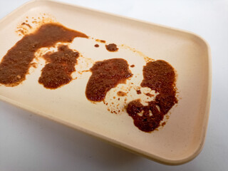 Dirty plate isolated, empty bowl after dinner, ready lunch, smeared ketchup sauce on white plate background.