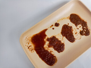 Dirty plate isolated, empty bowl after dinner, ready lunch, smeared ketchup sauce on white plate...