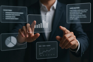 Businessman interacting with digital graphs and charts in dark office  