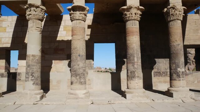Perspective view of a window inside a colonnade in the famous temple named "Philae", Aswan, Egypt. Ancient columns with hieroglyphics at both sides.
