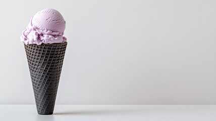 Single black ice cream cone with purple ube ice cream on white background.
