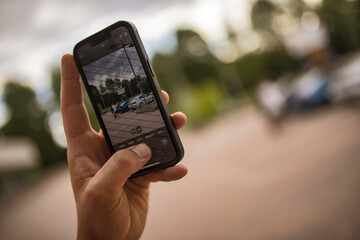 Person taking photo of parked cars with smartphone camera app