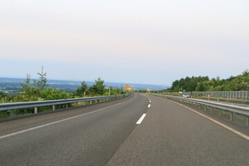 Countryside Drive: Road Signs and Guardrails Under Blue Sky
