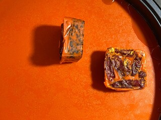 Two solid Sichuan hot pot base cubes, embedded with chili peppers, Sichuan peppercorns, and beef...