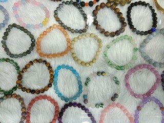 Colorful collection of handmade bracelets displayed in a glass case at a vibrant artisan market...