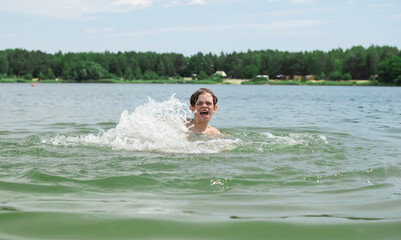 A little boy eats food on the beach after swimming