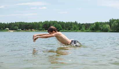 A little boy eats food on the beach after swimming