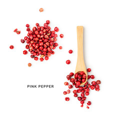 Pink peppercorns in wooden spoon and heap photography isolated on white background