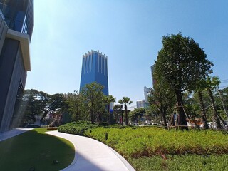 A glass building stands out against a blue midday sky.