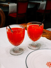 Refreshing red drinks served in elegant glasses at a cozy dining table