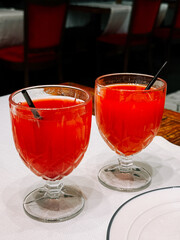 Refreshing fruity drinks served in elegant glasses at a dining table during evening hours