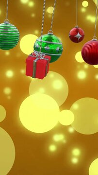 Animation of christmas baubles decoration and glowing spots on brown background