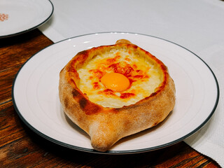 Delicious khachapuri with an egg served on a rustic plate in a cozy dining setting