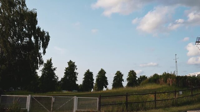 Camera Panning to Vintage German Wooden Windmill in Picturesque Countryside Landscape Under Blue Sky. 