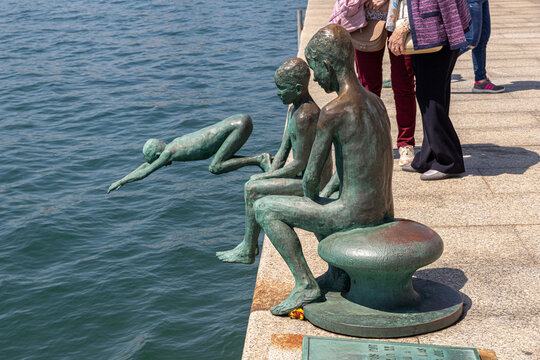 Santander, Spain. The Raqueros monument by the waterfront shows bronze figures of boys near the bay, capturing a moment of local maritime history and daily life