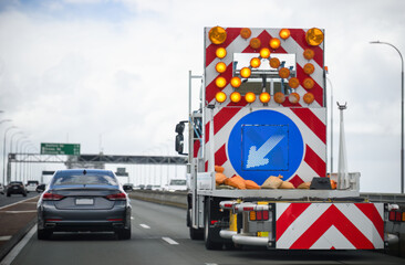 Work truck with arrow sign on Harbour Bridge. Lane closure due to strong wind. Auckland.
