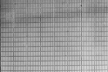 Monochrome metallic grid offers a textured surface with a repetitive rectangular pattern. The gray...