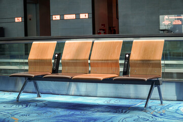 A row of vacant modern seating provides a stark contrast against the blurred backdrop, conveying a...