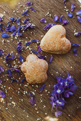 cookies on a beautiful background old wooden surface with petals of faded blue flowers scattered on the table. High quality photo