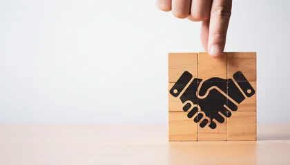 Naadloos Fotobehang Airtex Hand assemble wooden block cube which print screen black business handshake icon for partnership deal agreement and collaboration concept. © Dilok