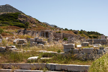 Ancient ruins in Turkiye surrounded by green hills and grass. The site features stone structures...