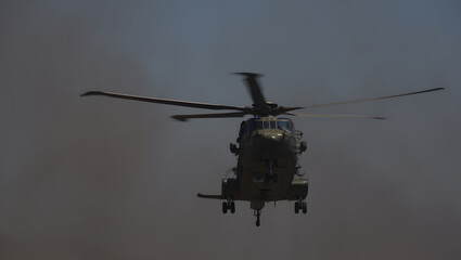 Fototapeta premium Military Helicopter in Flight, Dramatic Low-Angle Shot, Haze Background, Powerful, Serious Mood.