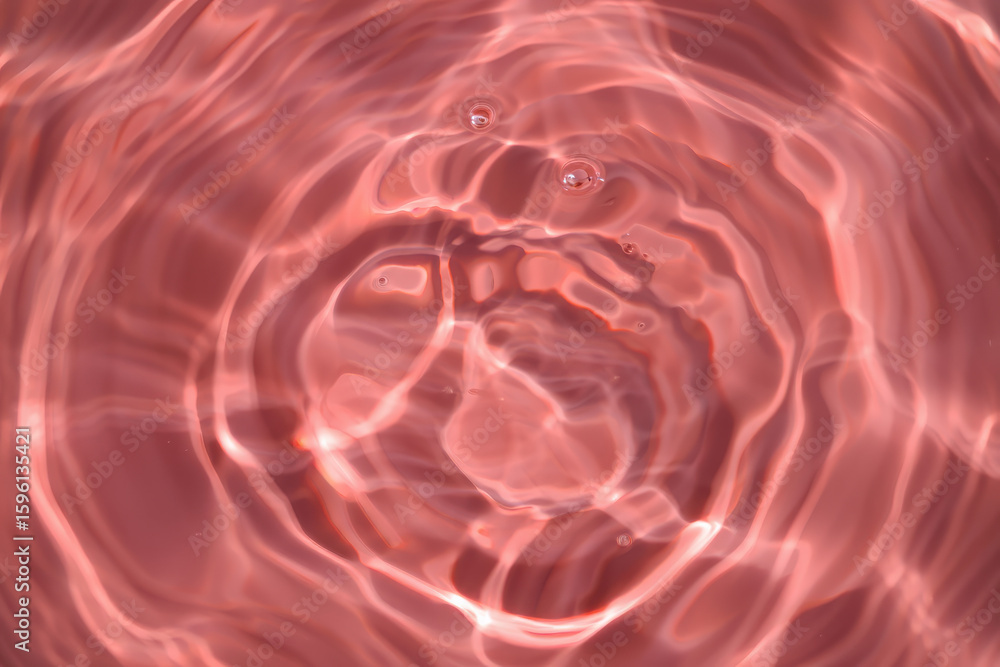 Poster rose colored water ripples creating concentric circles with a few visible small bubbles on the surfa