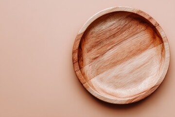Empty wooden plate on a peach background.