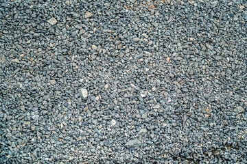 A textured surface filled with small, angular stones and pebbles, perfect for backgrounds and designs emphasizing natural textures. This detailed image offers a gritty, earthy feel and depth.