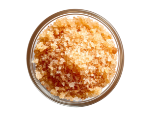 exfoliating body scrub made of natural brown sugar and sea salt in a clear glass bowl for skincare and spa treatment on isolated background
