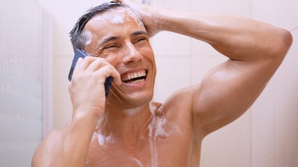 Happy man talking on mobile phone while taking shower