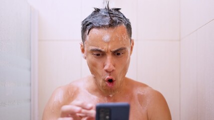 Surprised man checking his smartphone while taking a shower