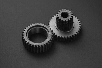 Two gears are placed side by side on a dark gray surface.
