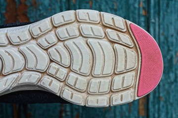 part of one old dirty red white plastic shoe sole on a green background