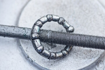 bicycle parts made of gray round metal bearing on long bolt threaded axle lie on table