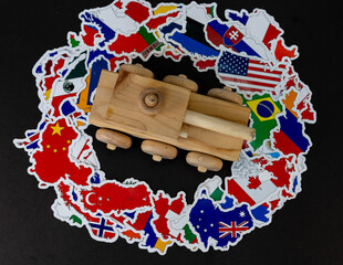 Wooden Toy Tank Over Country Flags on Black Background