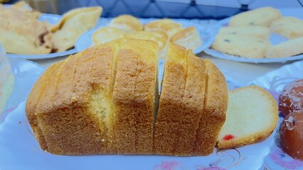 Artisanal Bread Display &ndash; Sliced Loaf and Sweet Pastries on Rustic Tabletop