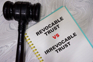 Concept of Revocable trust VS irrevocable trust write on book with gavel isolated on Wooden Table.