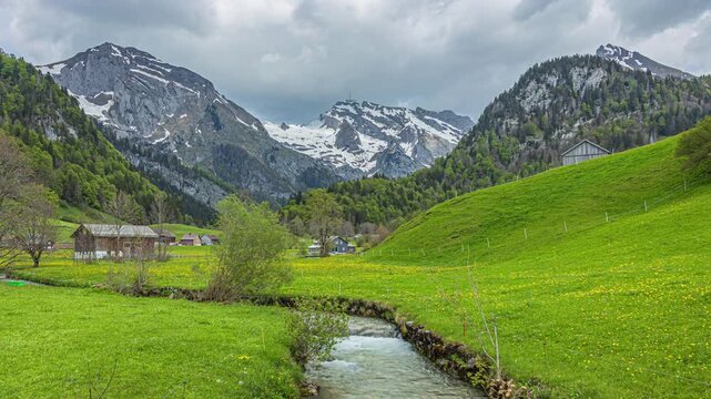 Time lapse, view on snowy mountain peak above the forest. Saentis mountain peak in the Appenzell Alps. Switzerland