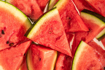 Close-up of fresh watermelon slices on red background, top view summer fruit composition
